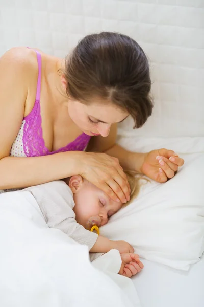 母親が赤ちゃんの額の温度をチェックします。 — ストック写真