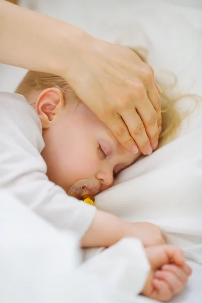 Detailní záběr na matku, kontrola teploty čelo dítěte — Stock fotografie