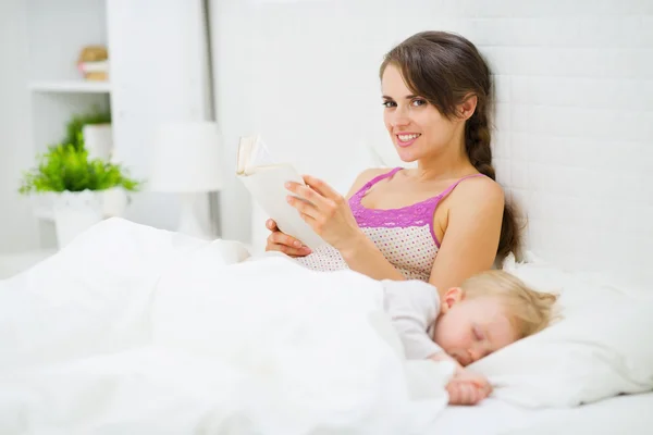 母亲在床上，而婴儿阅读 — 图库照片