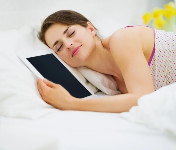 Mulher feliz dormindo abraçando tablet PC — Fotografia de Stock