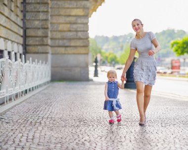 Mother and baby walking in city