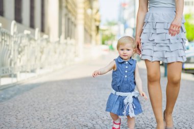 Baby with mother walking in city