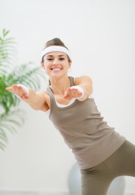 Smiling healthy woman making gymnastics exercise clipart