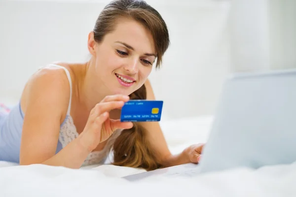 Mutlu kadın yatakta laptop ile döşeme ve internetten alışveriş — Stok fotoğraf
