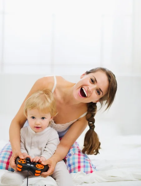 Mor leker med babyen på konsoll – stockfoto