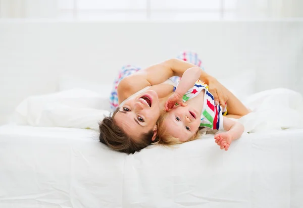 Mother playing with baby in bed — Stock Photo, Image