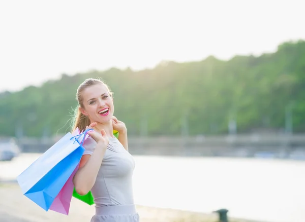Mujer feliz con bolsas de compras caminando muelle — Foto de Stock