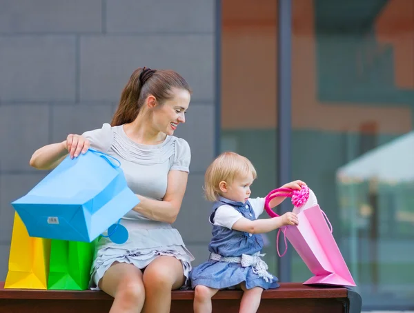 Mãe e bebê olhando para o saco de compras — Fotografia de Stock