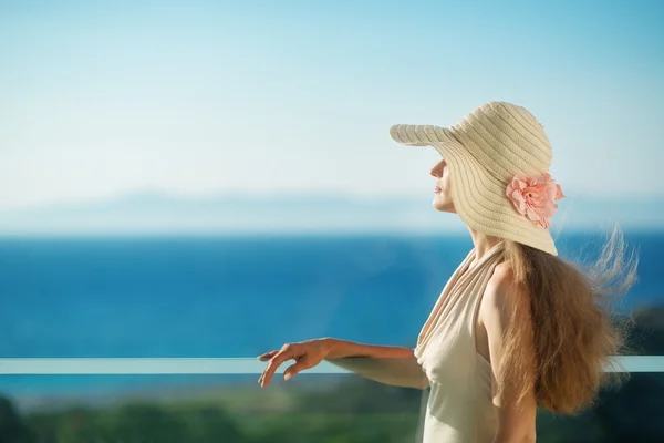 Γυναίκα κοιτάζει στη θάλασσα από το μπαλκόνι. Πίσω όψη — Φωτογραφία Αρχείου