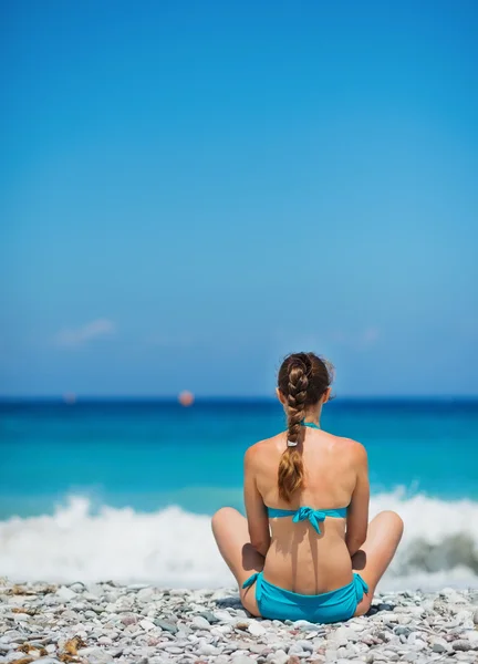 Žena sedící na břehu moře. zadní pohled — Stock fotografie