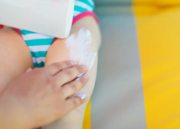 Κινηματογράφηση σε πρώτο πλάνο στο χέρι της μητέρας εφαρμογή Αντιηλιακή κρέμα στο μωρό πόδι — Φωτογραφία Αρχείου