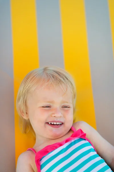 Portrait of laughing baby laying on sunbed — Stock Photo, Image