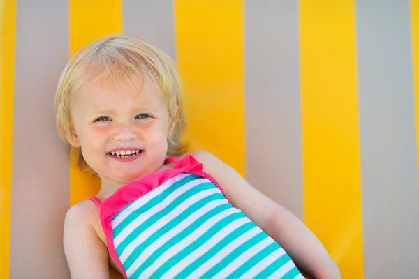 Porträt eines glücklichen Babys, das auf der Sonnenbank liegt — Stockfoto