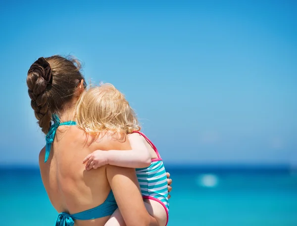 Matka s dítětem na pláži při pohledu do dálky. zadní pohled — Stock fotografie