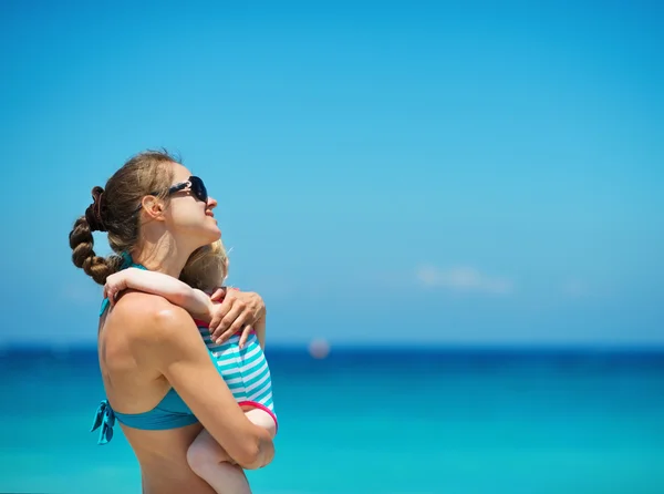 Moeder en baby omhelst op strand — Stockfoto