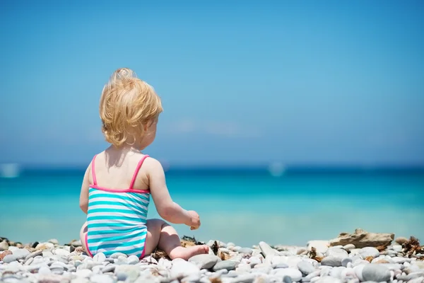 Dítě sedí na pláži. zadní pohled — Stock fotografie