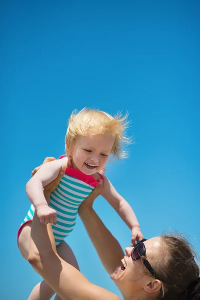 Mother raises baby in air — Stock Photo, Image