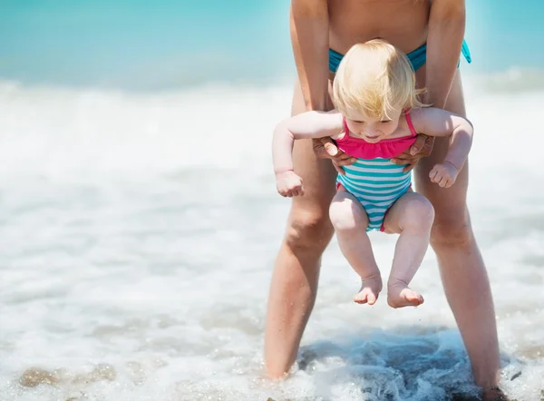 Mother and baby playing with sea waves — Stock Photo, Image