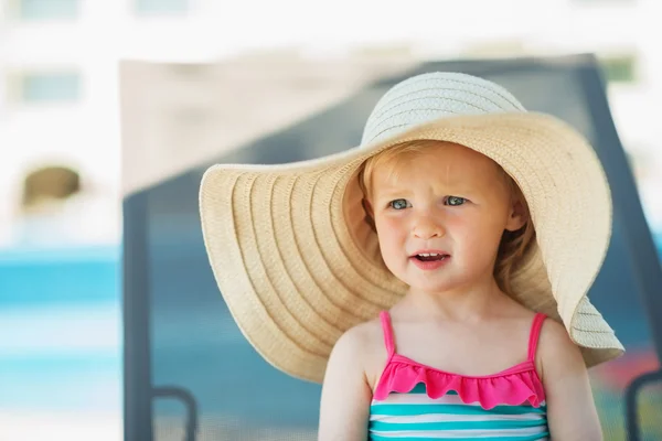 Portrait of baby in hat sitting on sunbed — Stock Photo, Image