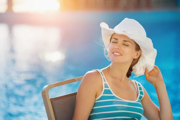 Šťastná žena sedí v baru u bazénu — Stock fotografie