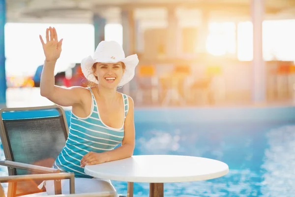 Lächelnde Frau an der Poolbar salutiert — Stockfoto