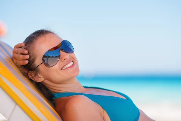 Donna sorridente sdraiata sulla spiaggia — Foto Stock