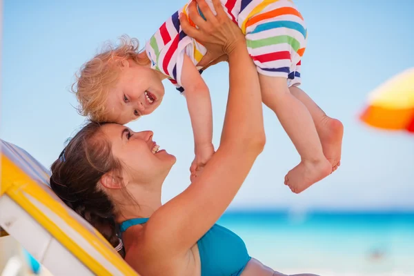 Happy mother playing with baby on sunbed — Stock Photo, Image