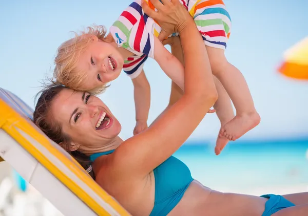 Portrait of mother playing with baby on beach — Stock Photo, Image