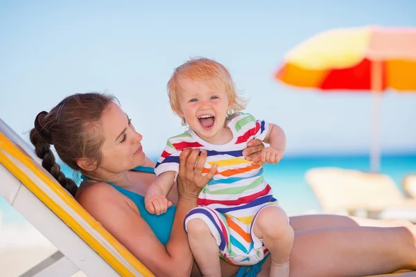 Portret van opgewonden baby met moeder op strand — Stockfoto