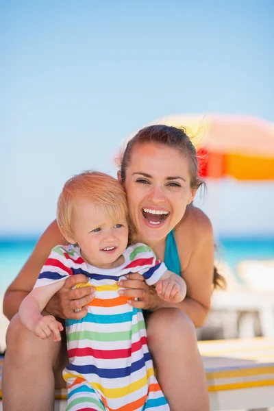 Portrait of happy mother and baby on beach — Stock Photo, Image