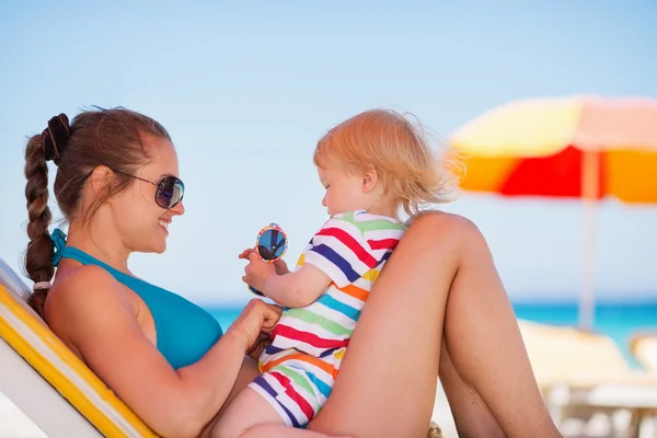 Gelukkig moeder in zonnebril spelen met baby — Stockfoto