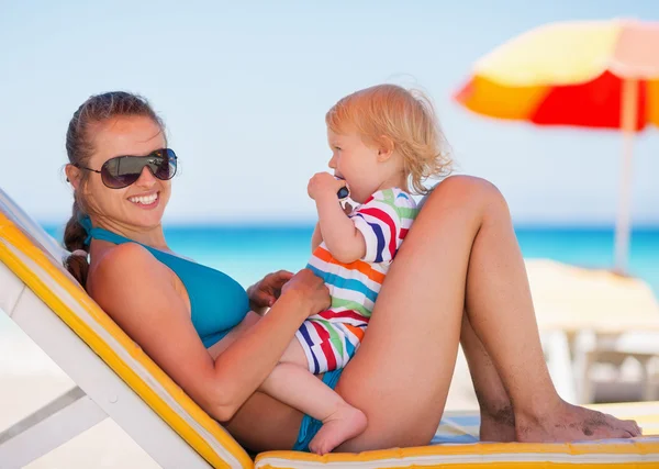 Portrait of happy mother and baby on sun bed — Stock Photo, Image