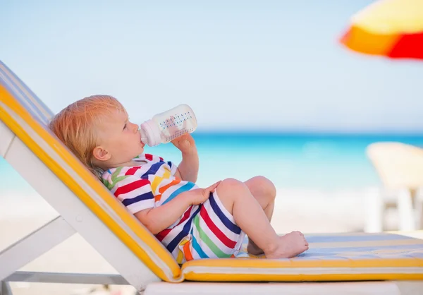 Portrait of baby on sunbed drinking water — Stock Photo, Image