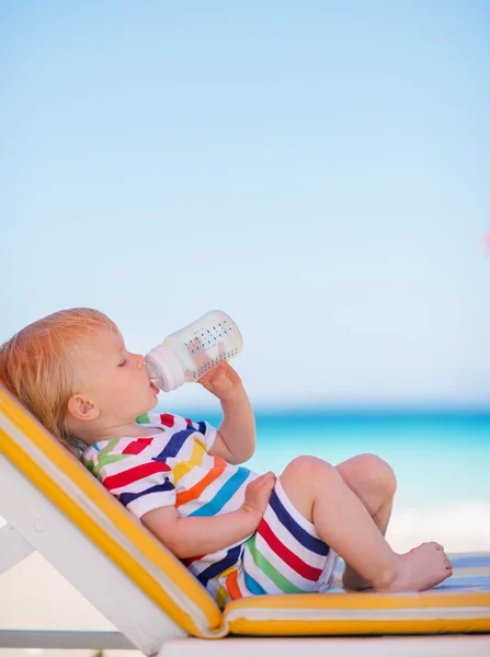 Portrait of baby on sun bed drinking water — Stock Photo, Image