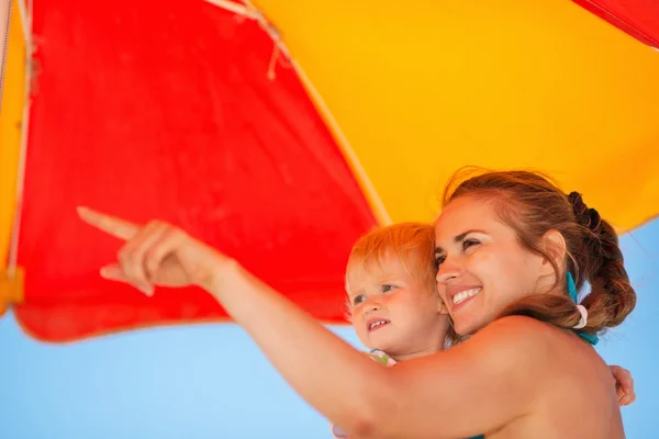 Mother showing something baby on beach — Stock Photo, Image