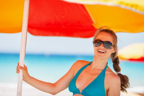 Portret van gelukkig vrouw op strand onder de paraplu — Stockfoto