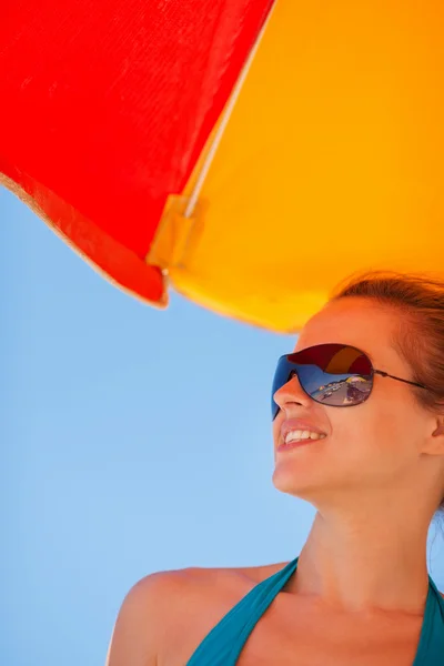 Mulher feliz em óculos de sol na praia olhando no espaço de cópia — Fotografia de Stock