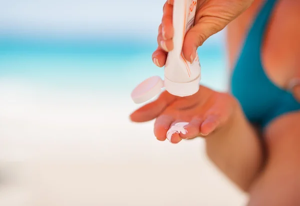 Primo piano su mano che stringe la crema di crema solare da un tubo — Foto Stock