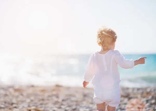 Bebê andando na praia. Vista traseira — Fotografia de Stock