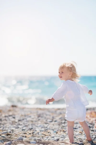 Bebé caminando en la playa y mirando en el espacio de copia — Foto de Stock