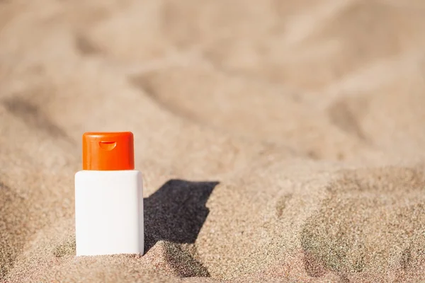Bottiglia di crema solare sulla sabbia — Foto Stock