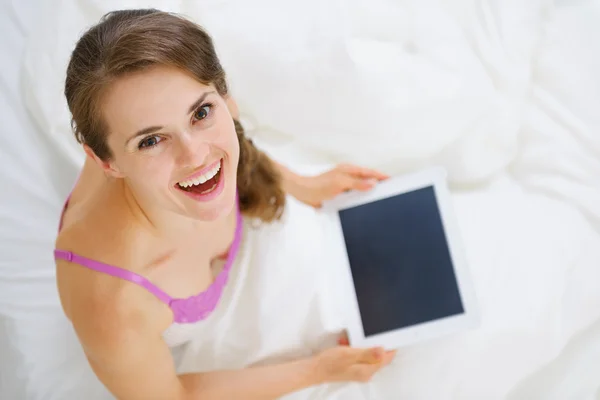 Usmívající se žena seděla v posteli a použití počítače tablet pc. horní pohled — Stock fotografie