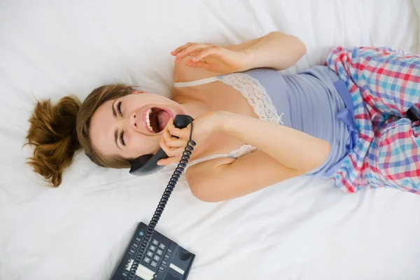 Exalterad tjej på sängen och talar telefon. övre Visa — Stockfoto