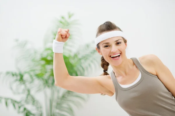 運動の女性示す上腕二頭筋を笑顔の肖像画 — ストック写真