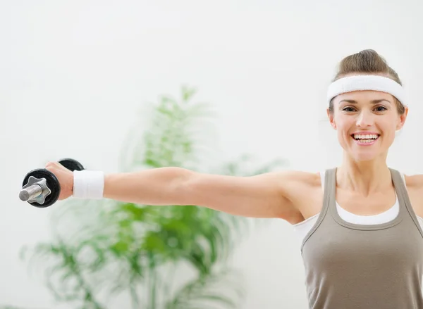 Smiling athletic woman making exercise with dumbbells — Stock Photo, Image