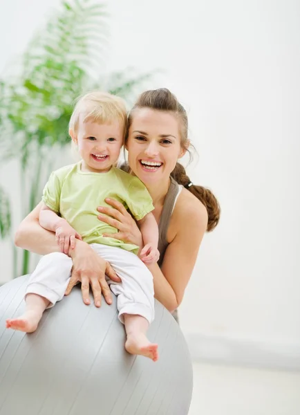Portrait of happy mother and baby in gym — Stock Photo, Image