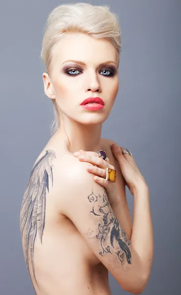Donna dall'aspetto vampiro con ali di tatuaggio sul retro Fotografia Stock