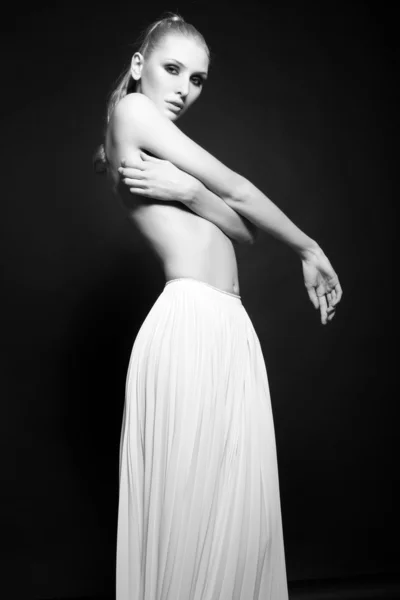 Semi naken blond kvinna i lång vit kjol Royaltyfria Stockfoton