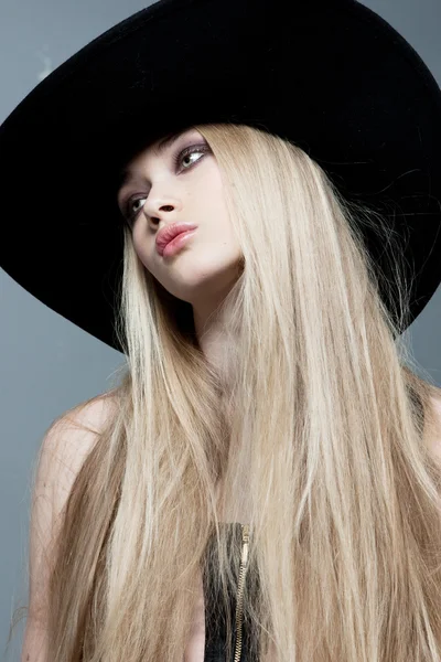 Vacker blond flicka stående i en hatt — Stockfoto