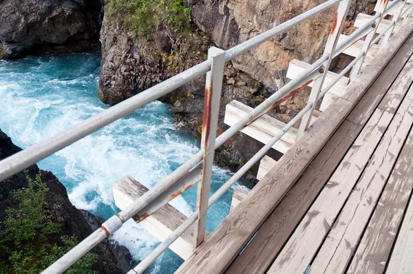 Ponte de madeira sobre canyon de água selvagem — Fotografia de Stock